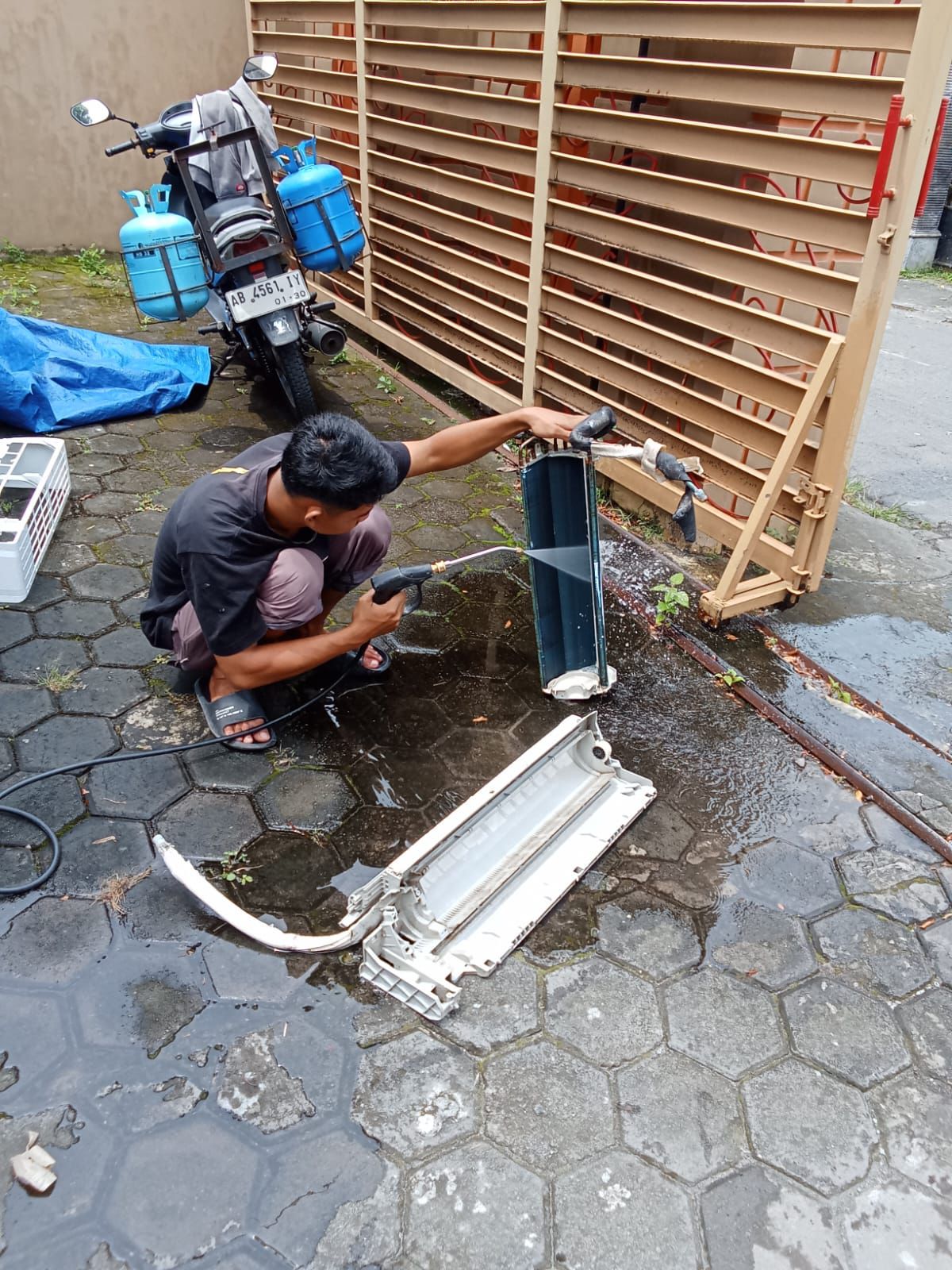 Teknisi membersihkan AC outdoor