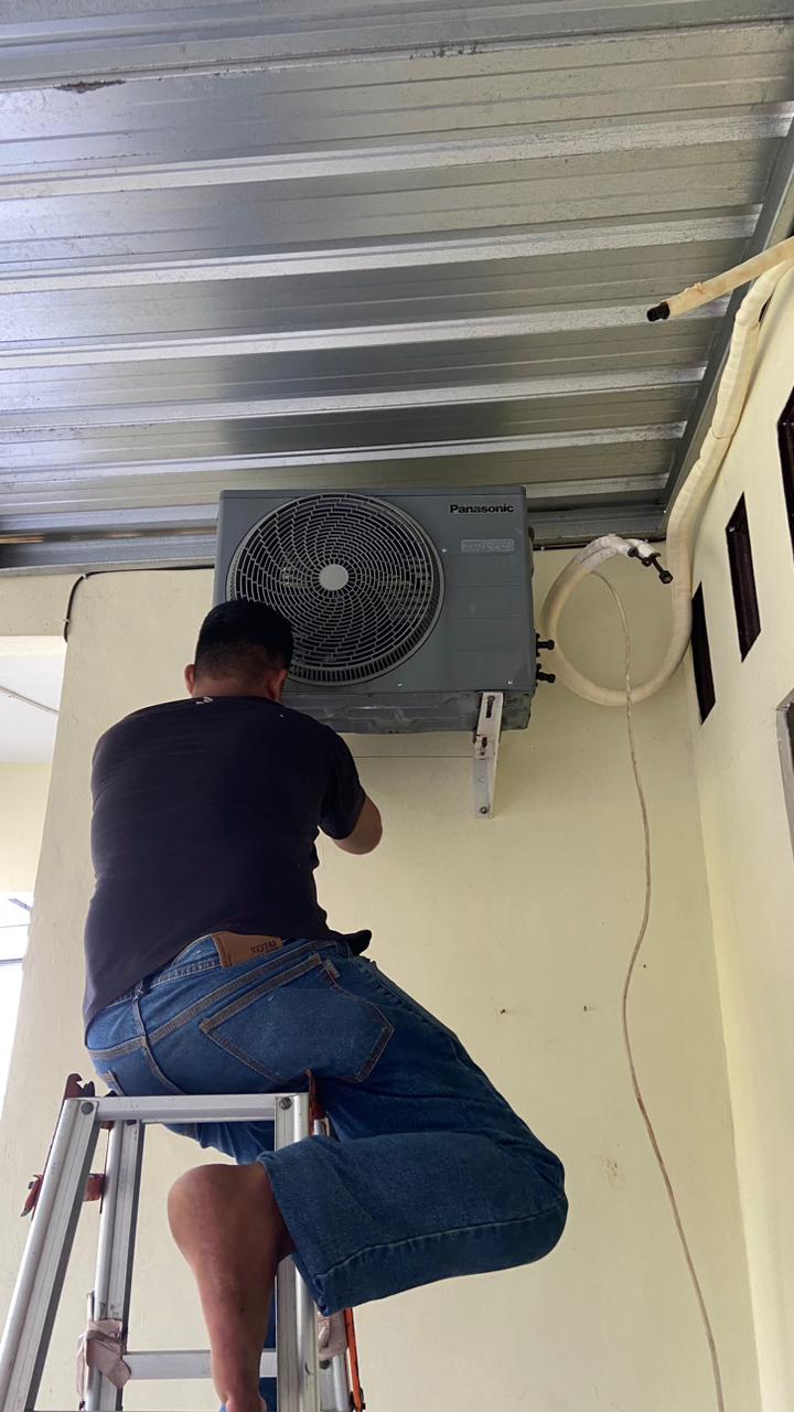 Teknisi memasang unit AC outdoor Panasonic